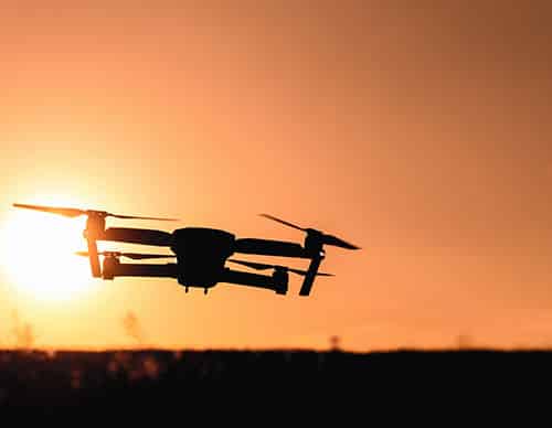 Drone silhouette with camera flying in the sunset light